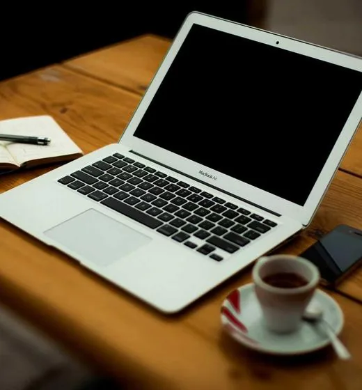 Workspace creativo con portatil y bocetos de diseño web: caso de CAC payback reducido con growth loops